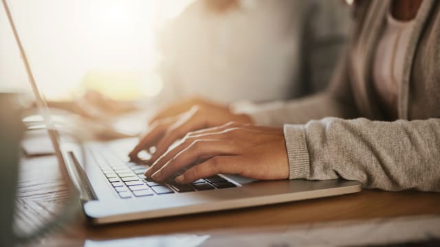 Womans hands typing on laptop