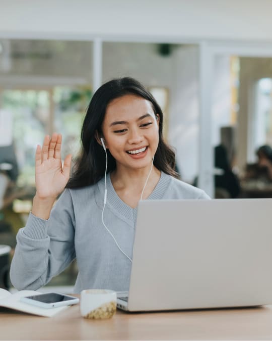 girl waving at laptop screen
